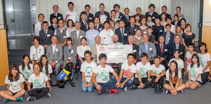 A large group of people are posing for a picture in a room.
