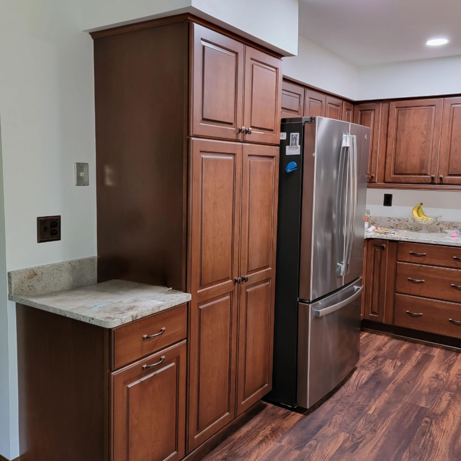 A kitchen under construction with wooden cabinets and white counter tops.