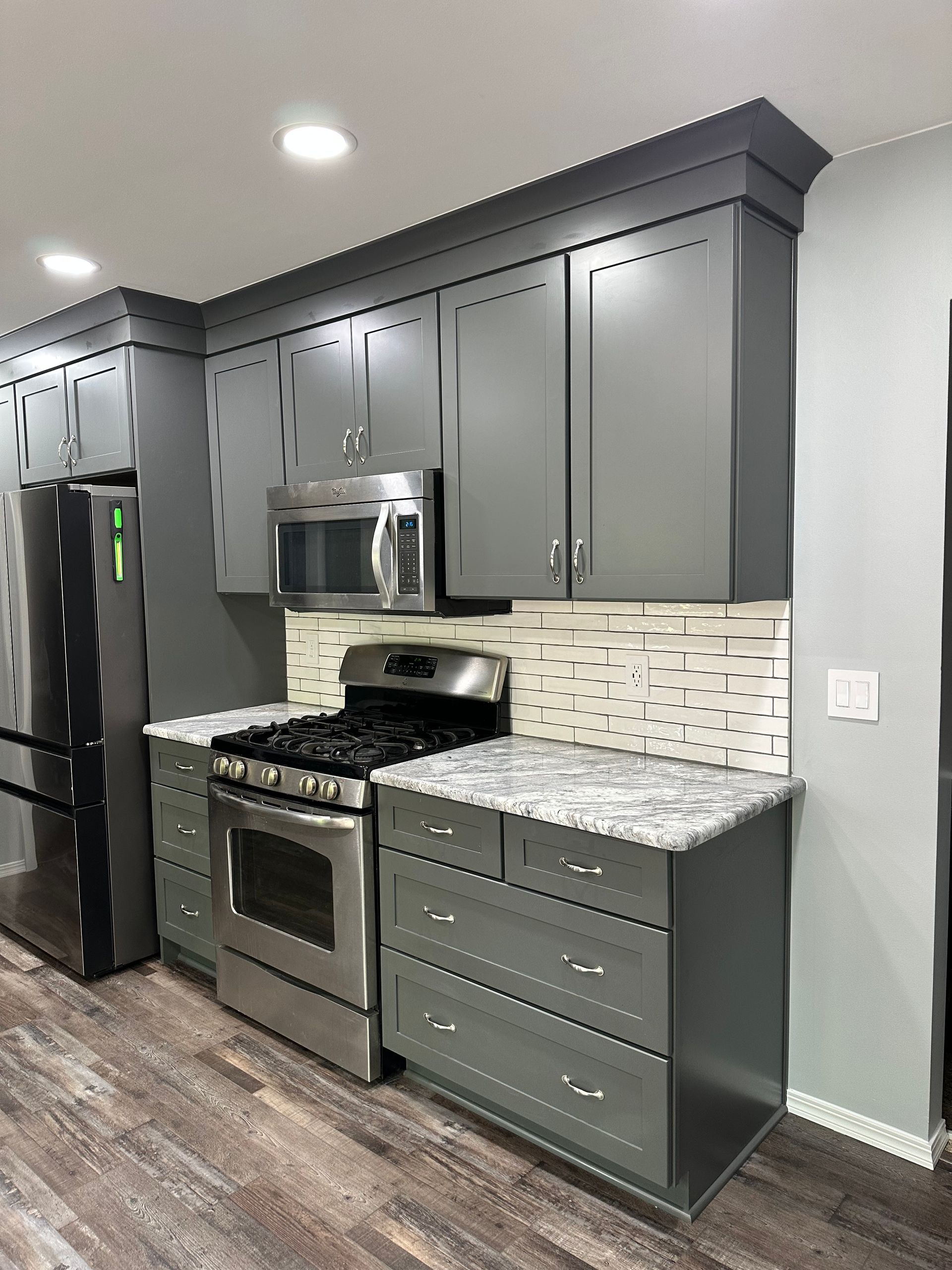 A bathroom sink with a granite counter top and wooden cabinets.