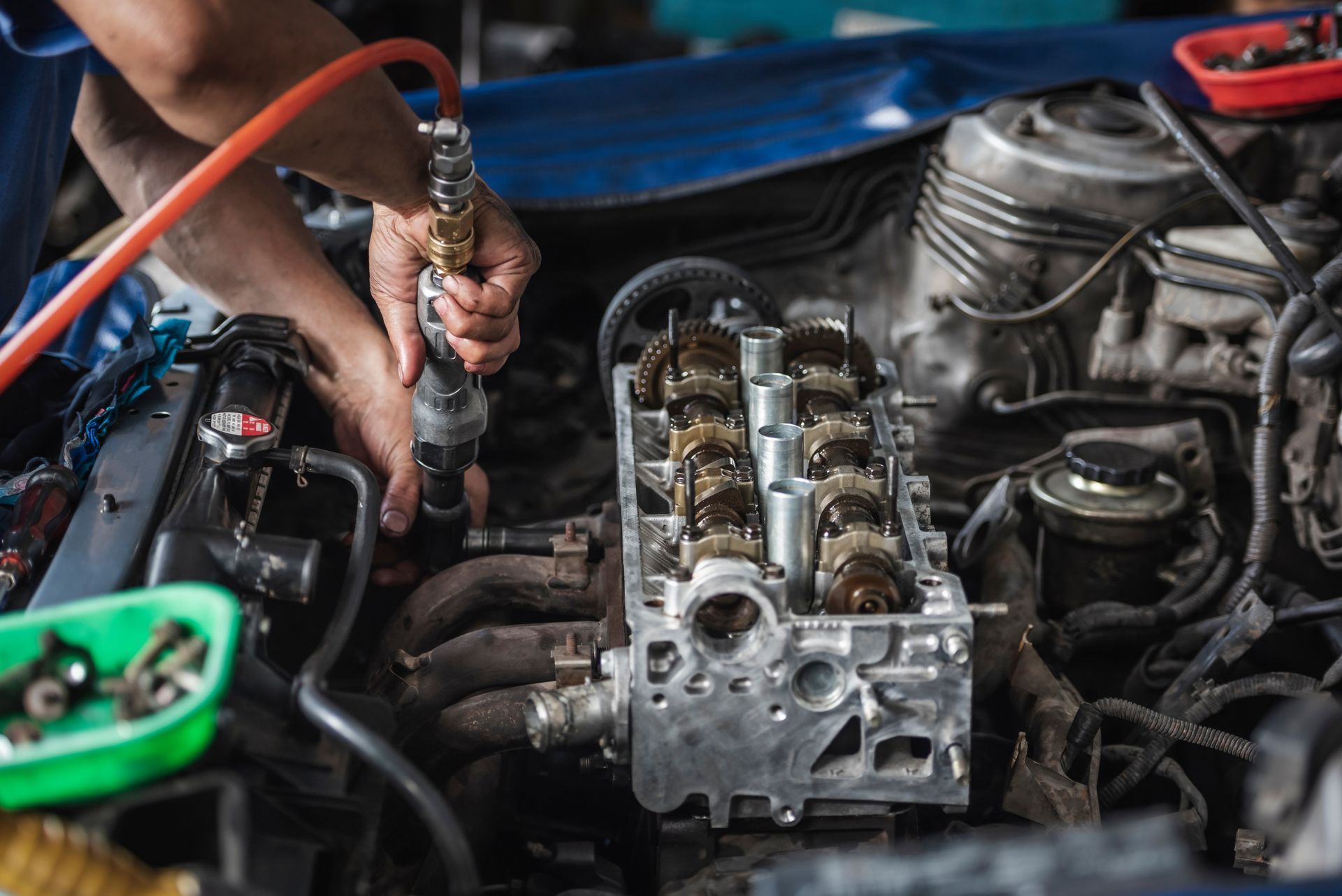A man is working on a car engine in a garage.