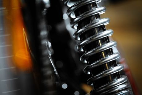 A close up of a shock absorber on a motorcycle.