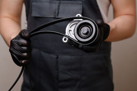 A man is holding a belt in his hands.