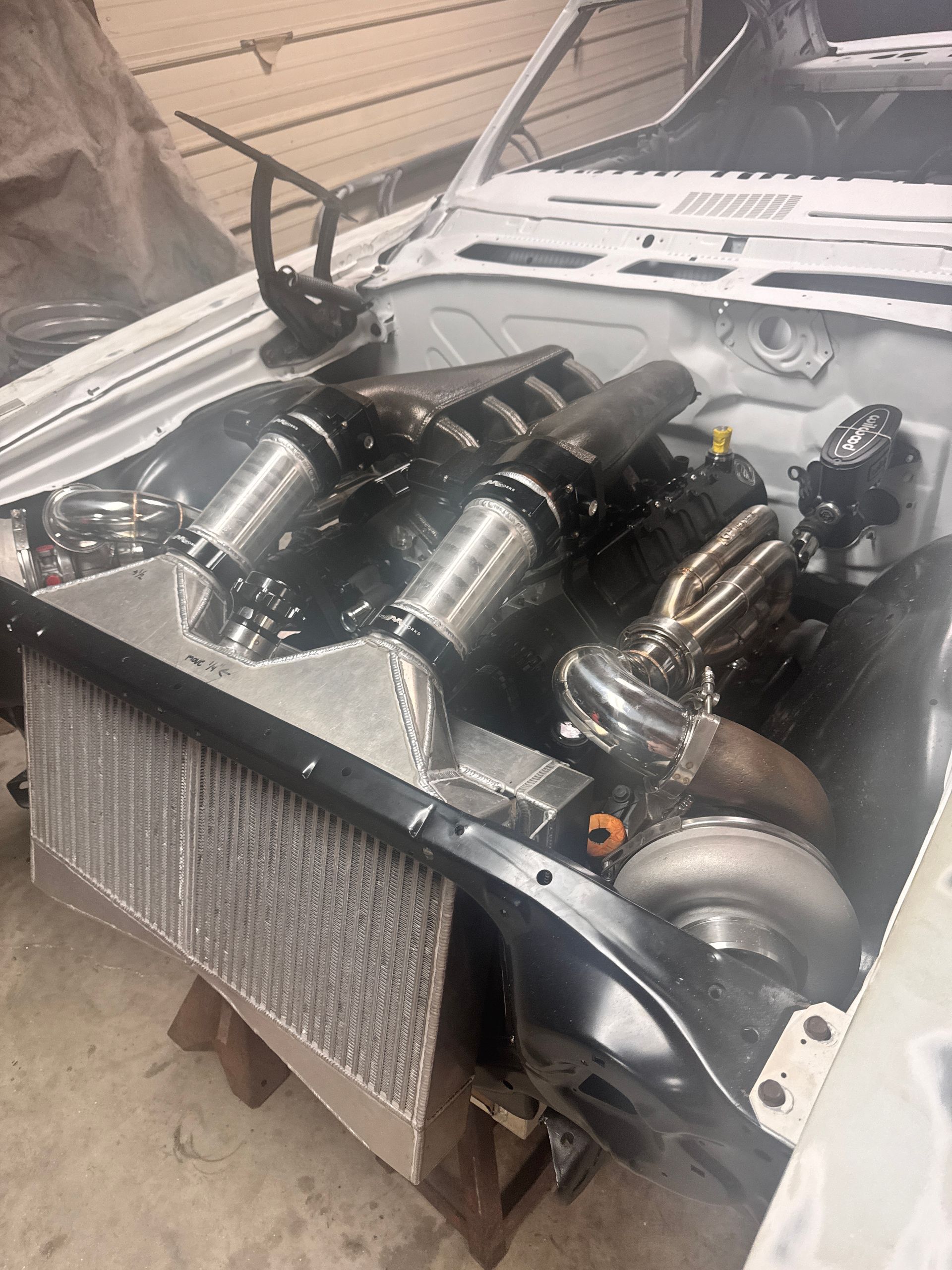 A car engine is sitting under the hood of a car.