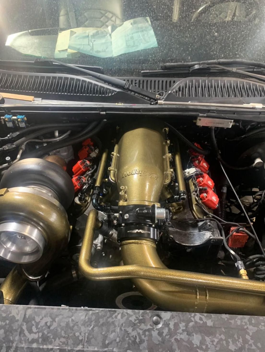 A close up of a car engine with the hood open.