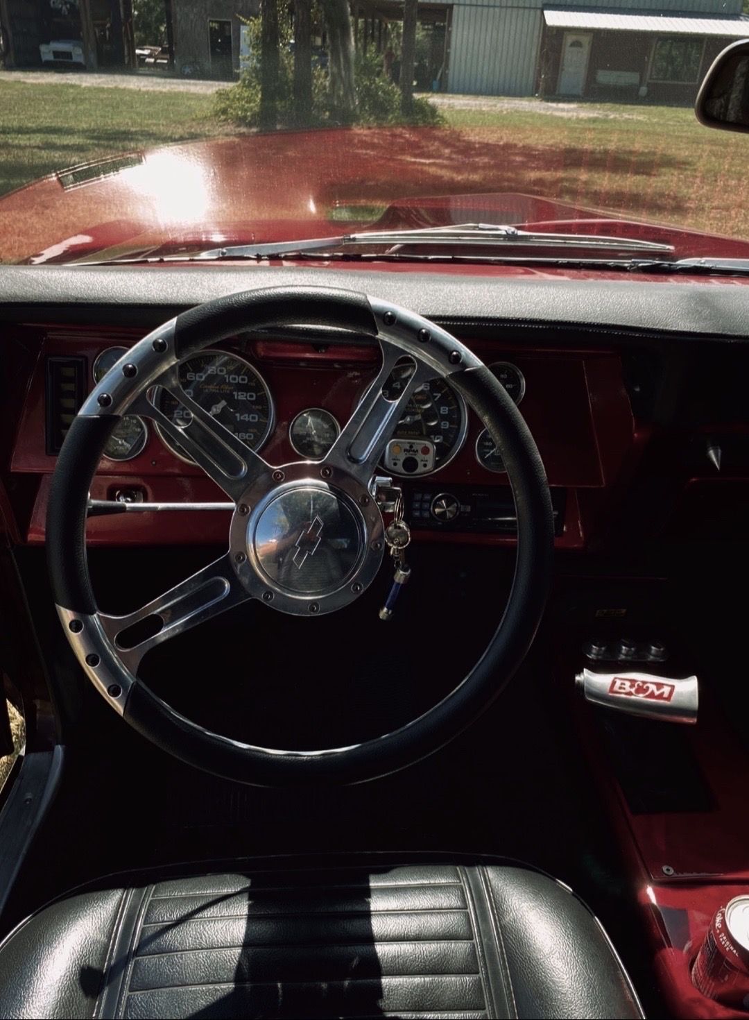 The inside of a red car with a steering wheel and dashboard.