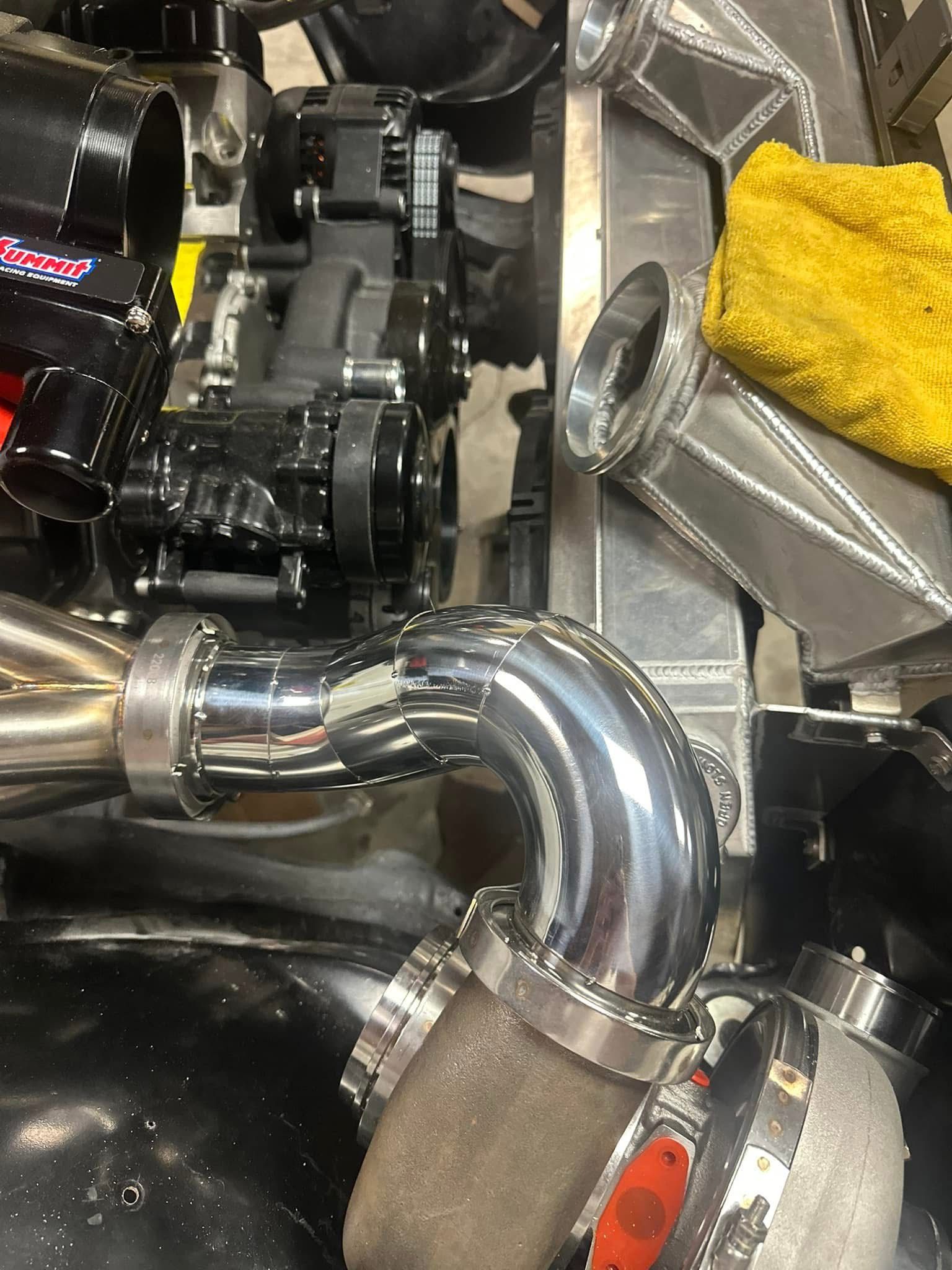 A close up of a car engine with a yellow towel on top of it.