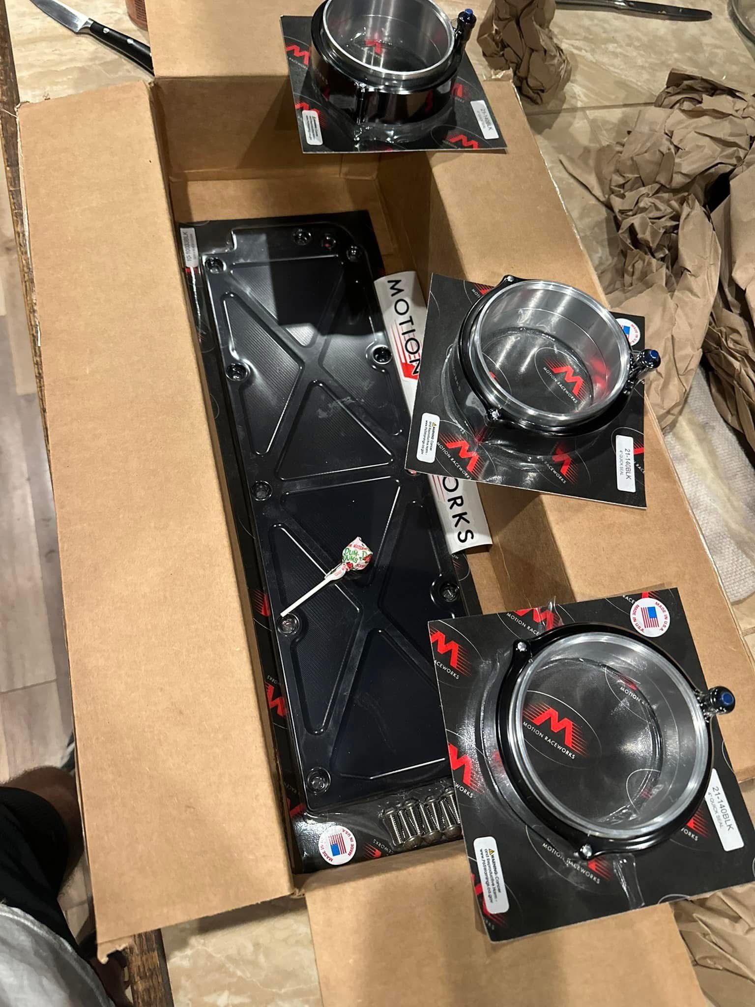 A bunch of pots and pans are sitting in a cardboard box.