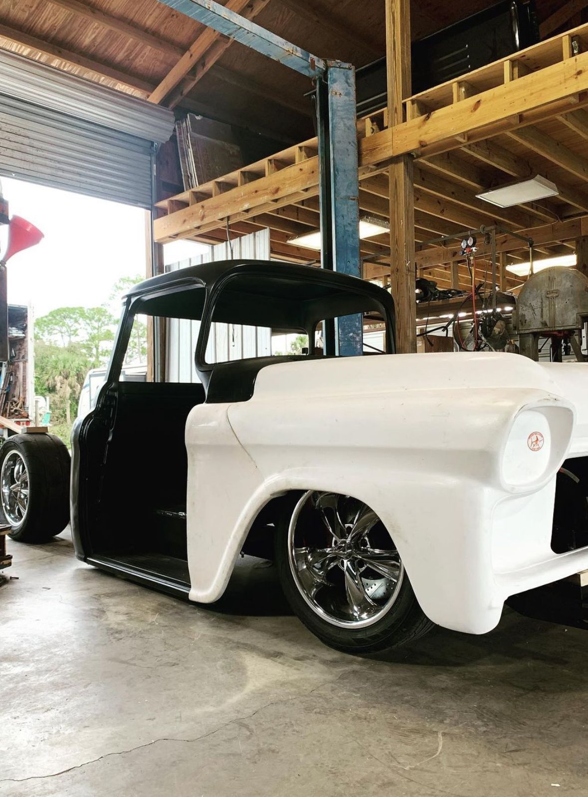 A black and white truck is parked in a garage.