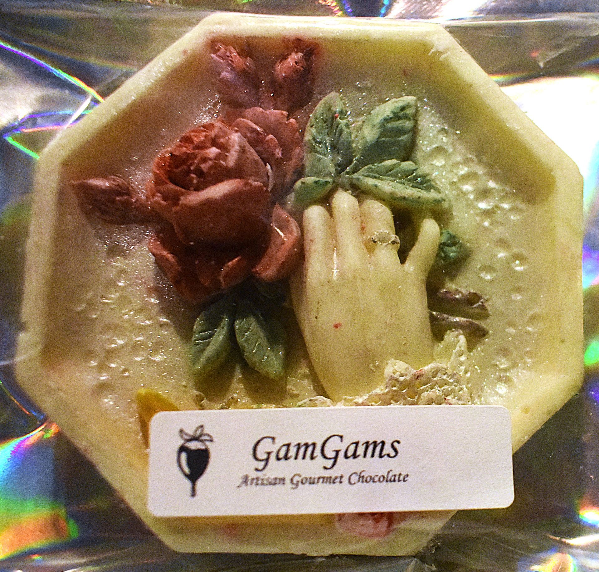 Chocolate featuring a hand with a ring, flowers, and the GamGams logo.