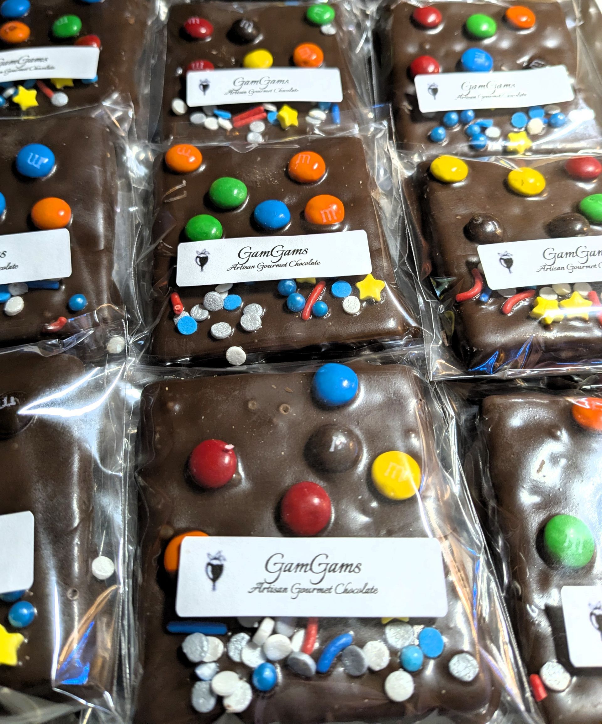 Chocolate treats with colorful candies and sprinkles, packaged in clear plastic.