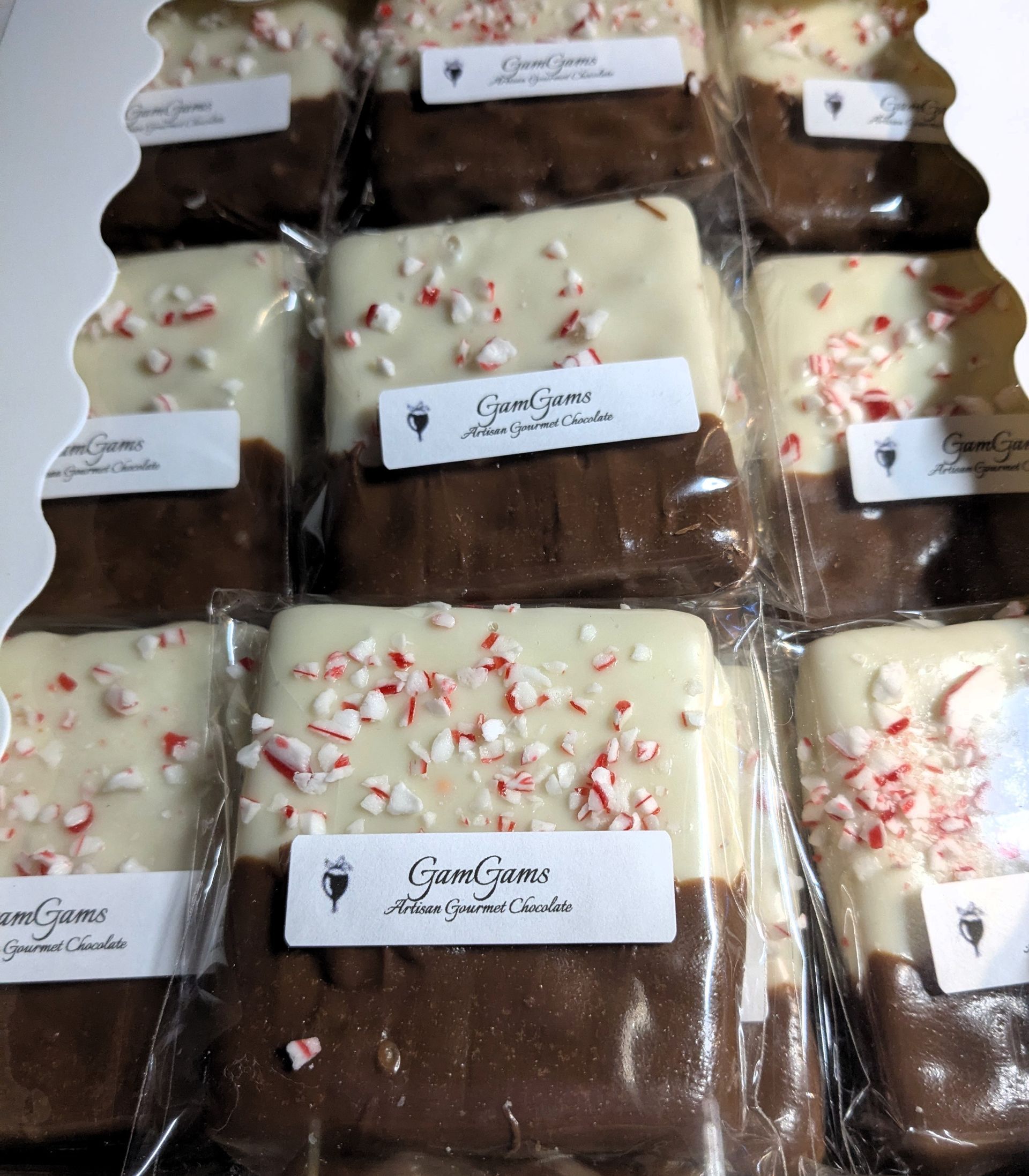 Chocolate bark squares, half dipped in white chocolate with crushed peppermint; packaged. Get it from GamGams Booth.