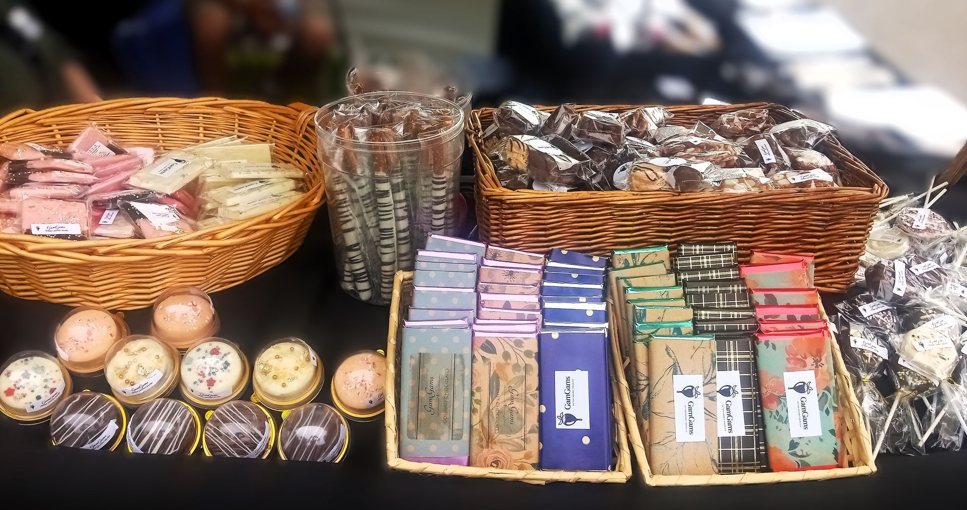 Display of various chocolates and baked goods at a vendor booth.