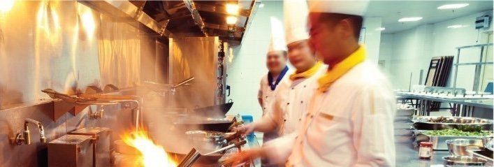 A group of chefs are cooking food in a kitchen.