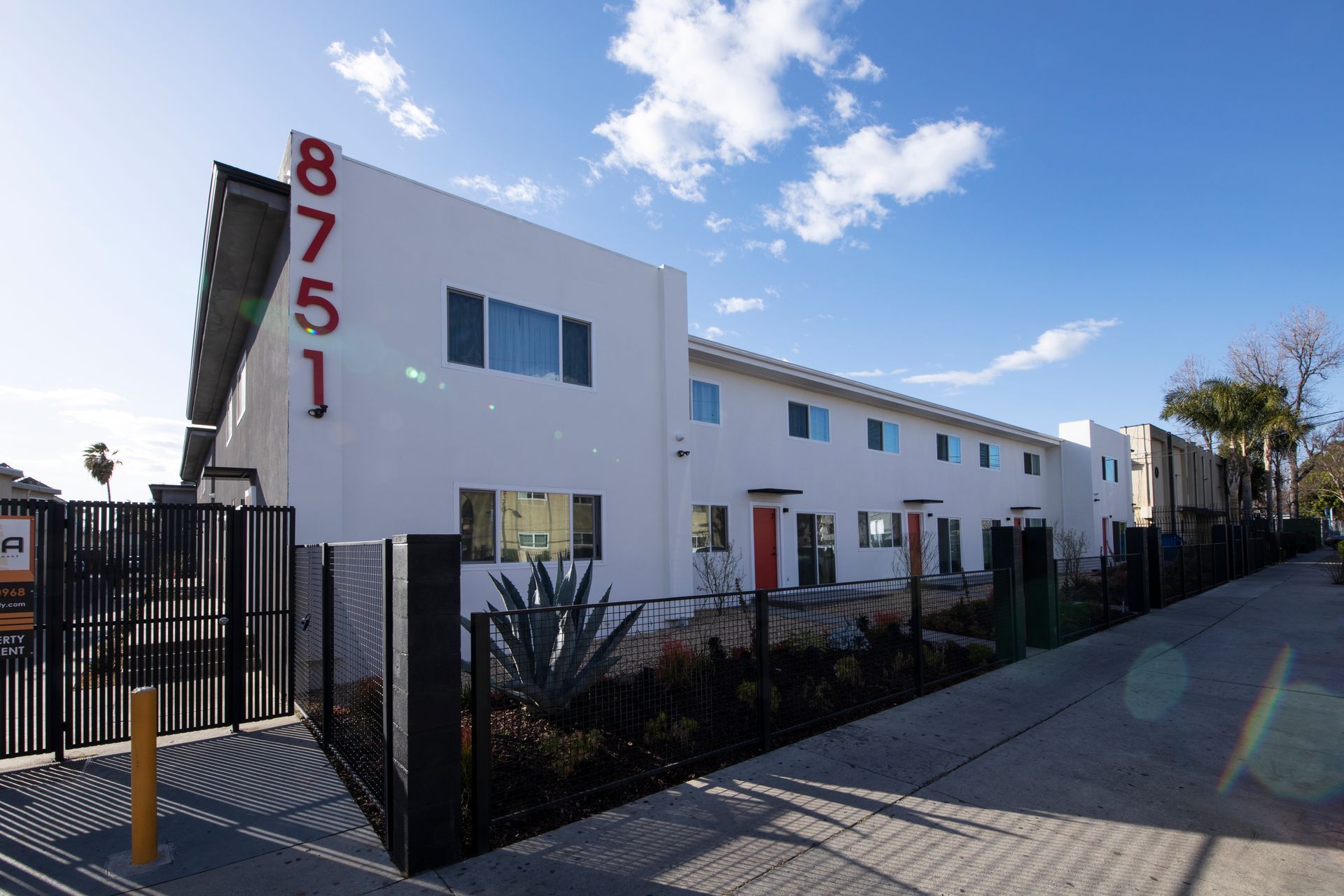 a white apartment building with the number 8751 on the side of it .