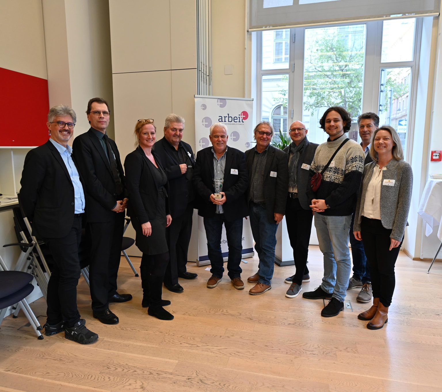 Eine Gruppe von Menschen posiert für ein Foto vor einem Schild mit der Aufschrift „rtb“
