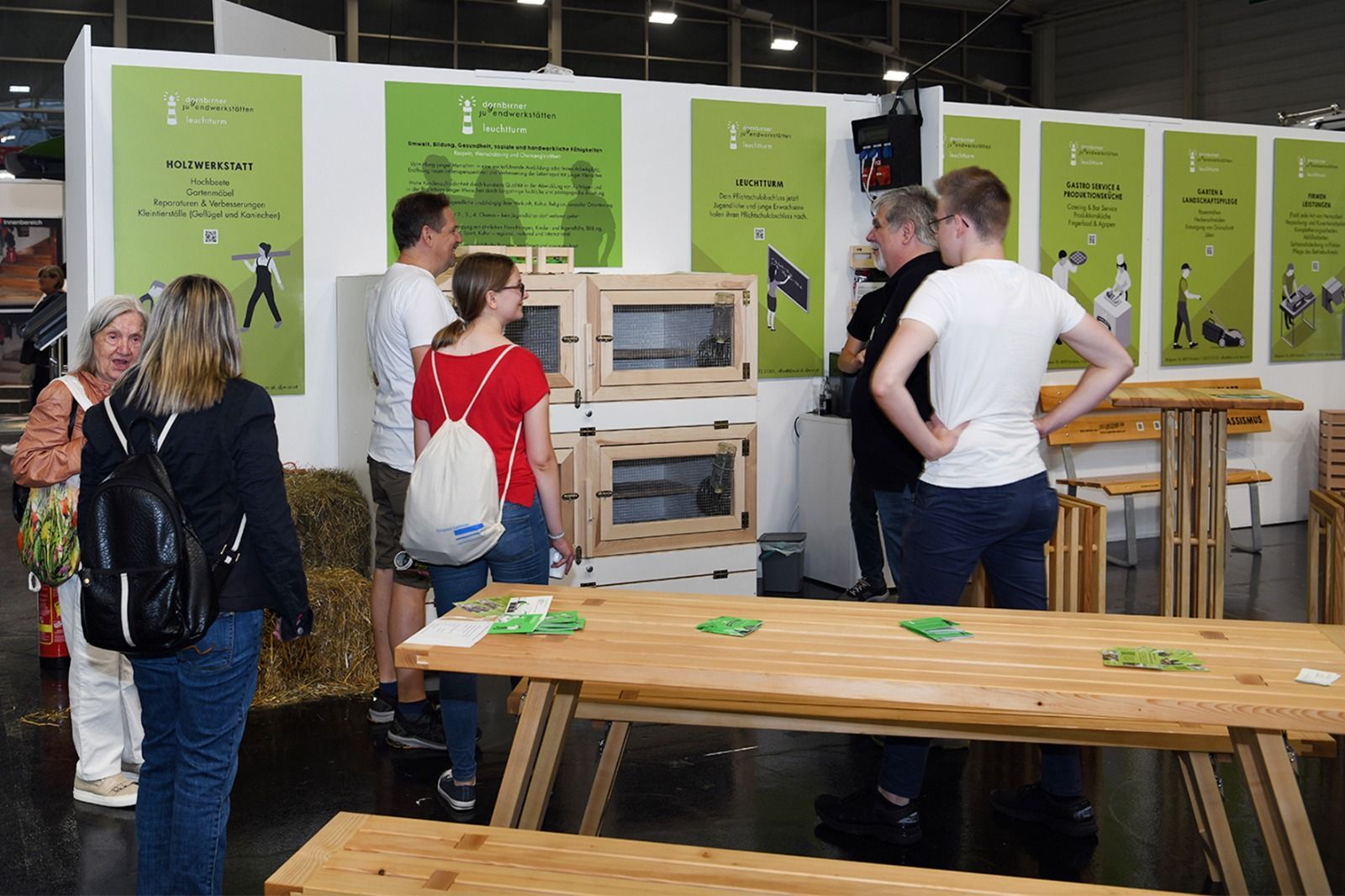 Eine Gruppe von Menschen steht um einen Holztisch herum.
