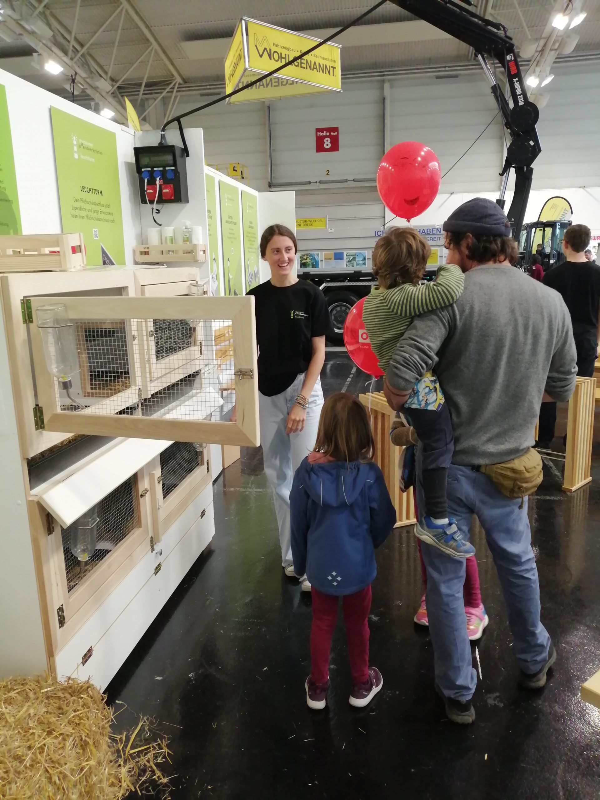 Eine Gruppe von Menschen steht vor einem Kaninchenkäfig