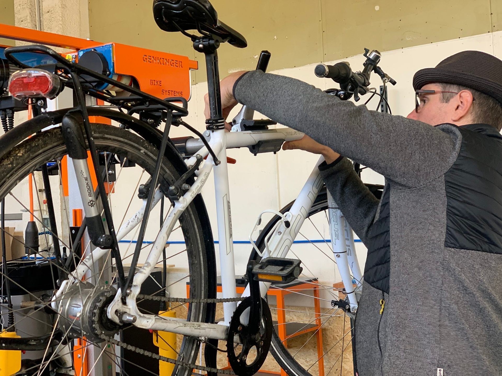 Ein Mann arbeitet in einer Garage an einem Fahrrad.