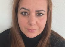 Eine Nahaufnahme des Gesichts einer Frau, die einen schwarzen Rollkragenpullover trägt.