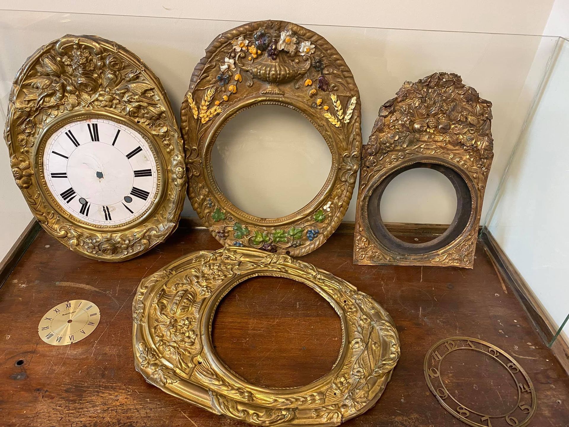 A group of clocks are sitting on top of a wooden table.