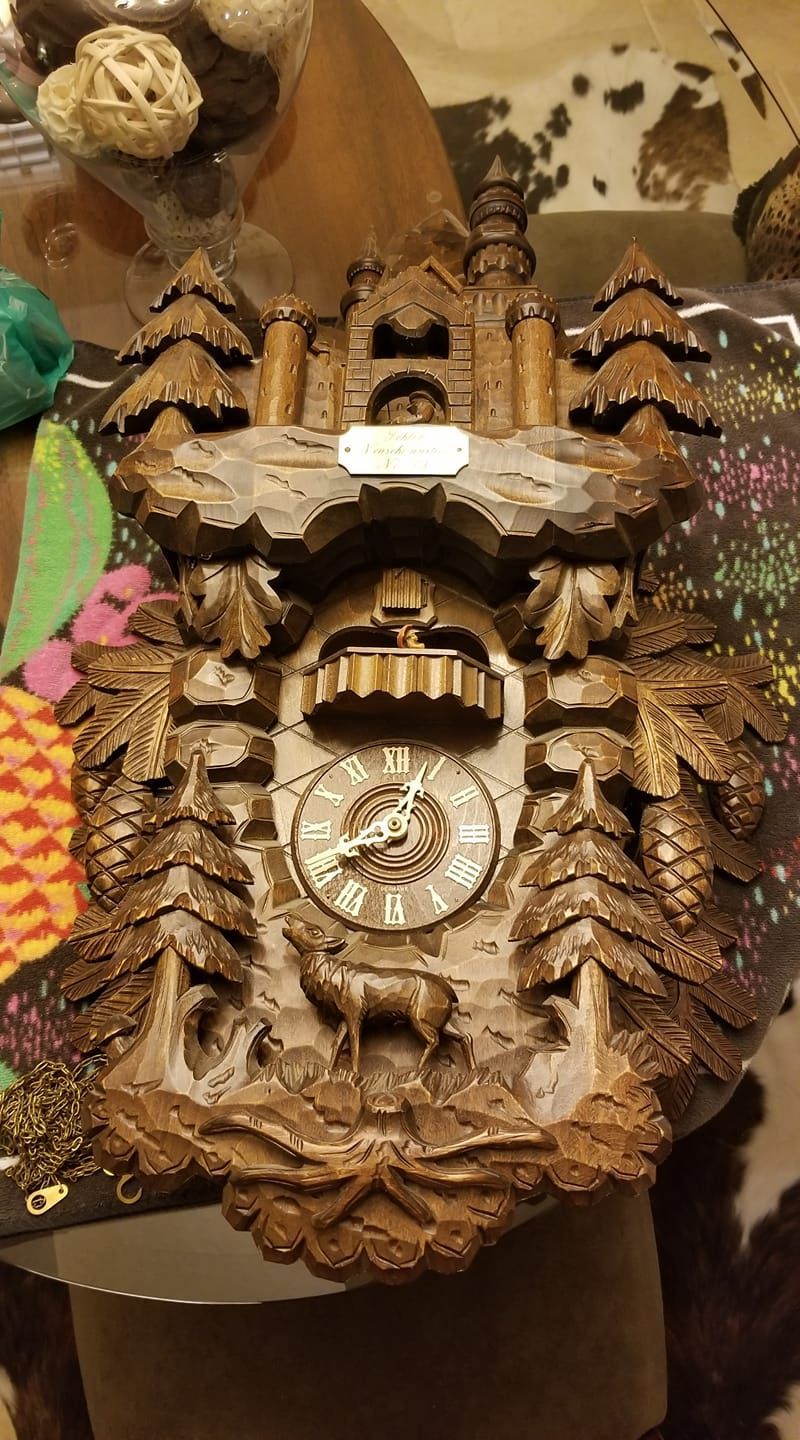 A wooden cuckoo clock is sitting on a table.