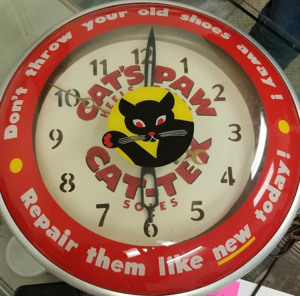 A cat 's paw clock that says do n't throw your old shoes away