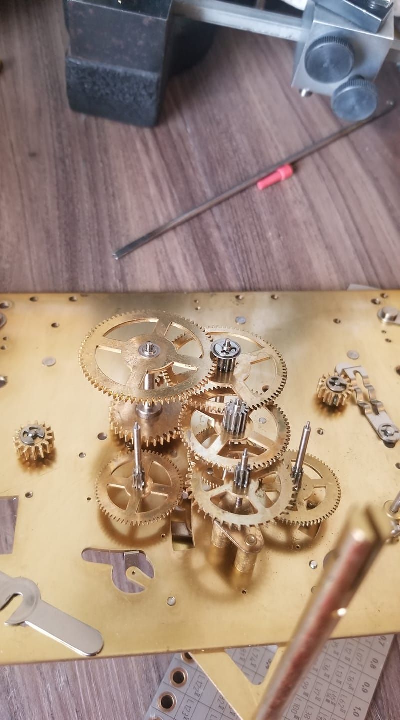 A close up of a clock mechanism on a wooden table.