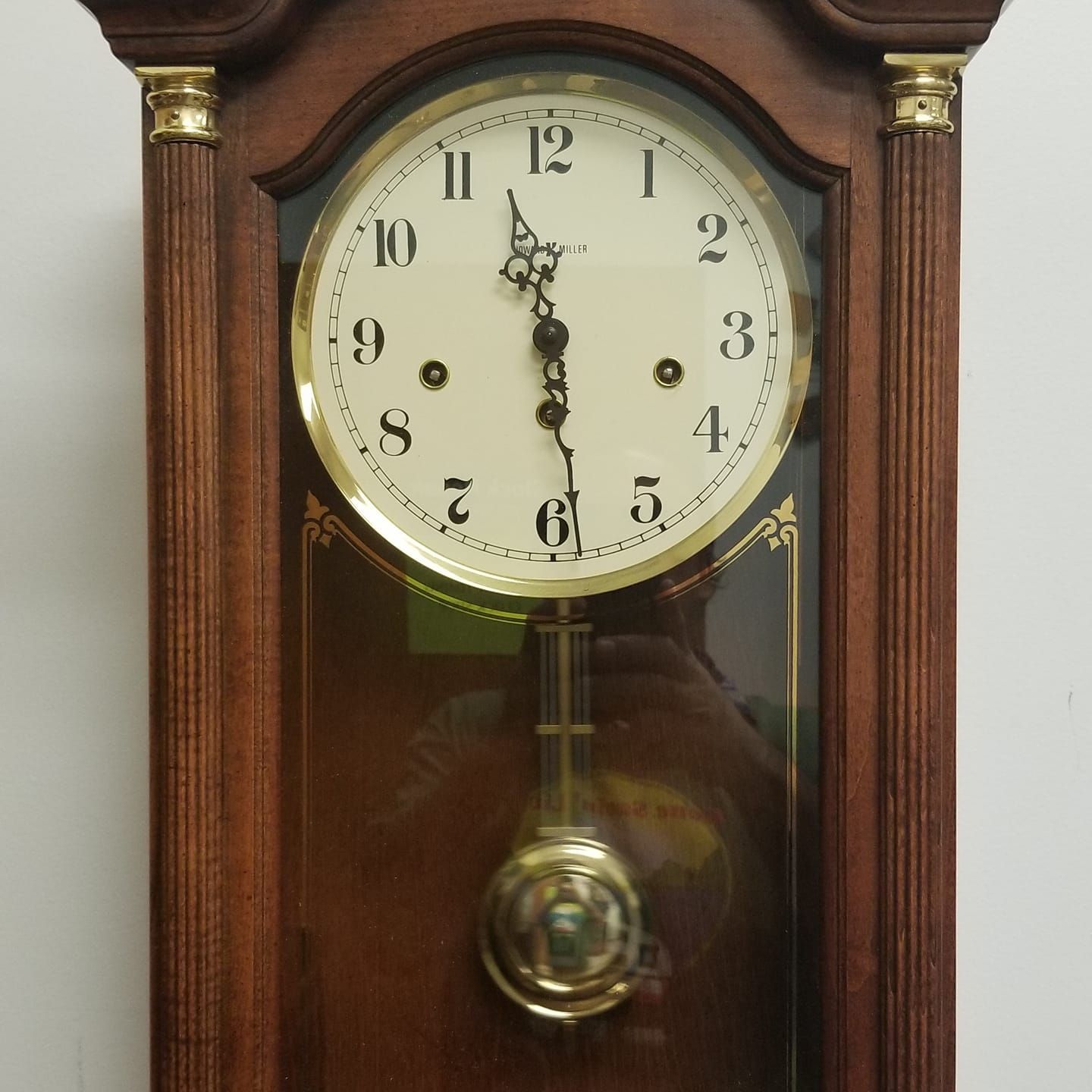 A wooden grandfather clock with the hands on the numbers 1 and 12