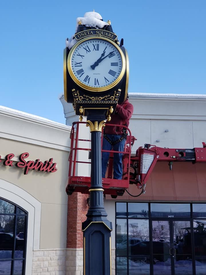 A man is working on a clock outside of a store called spirits