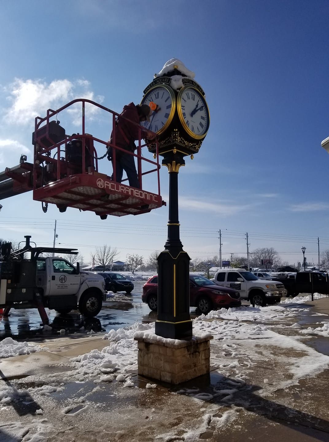 A man is working on a clock in a parking lot