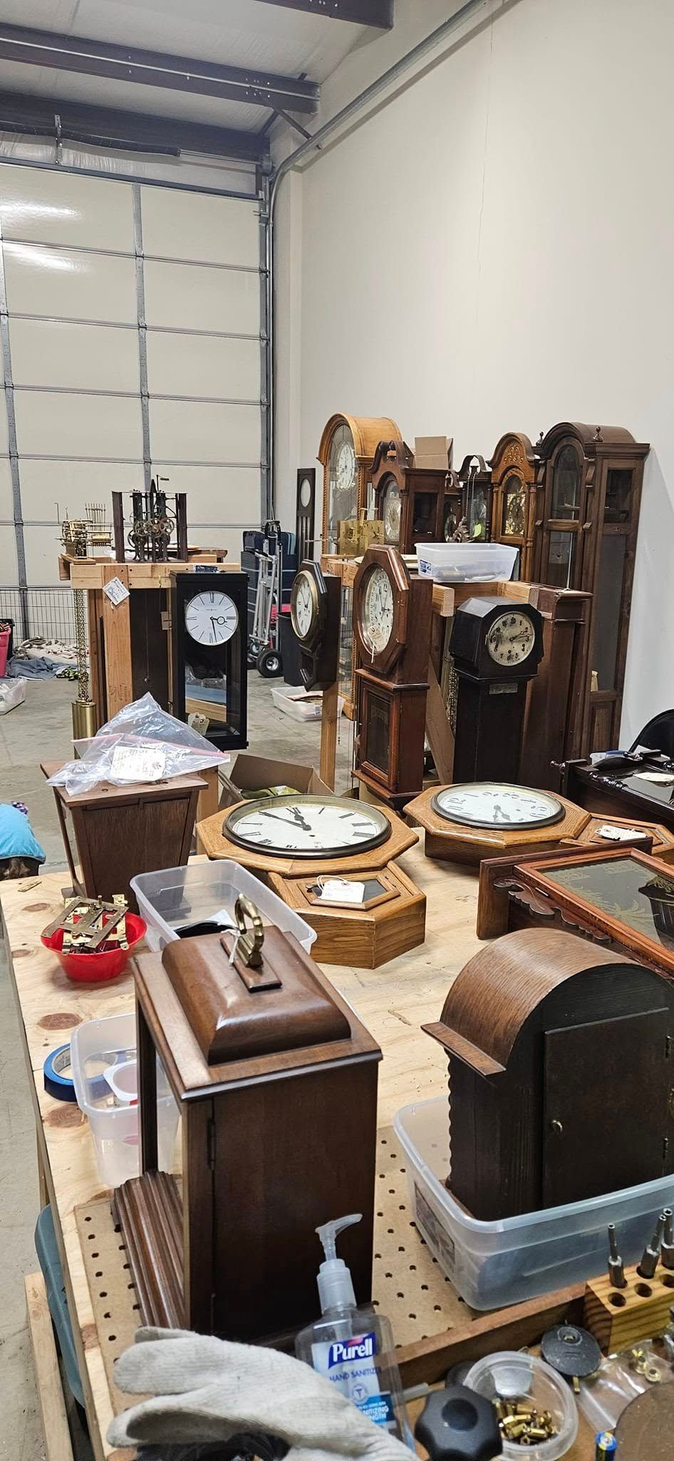 A room filled with lots of clocks on tables.