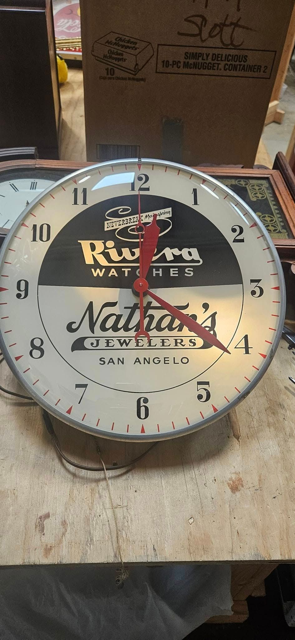 A clock is sitting on top of a wooden table.