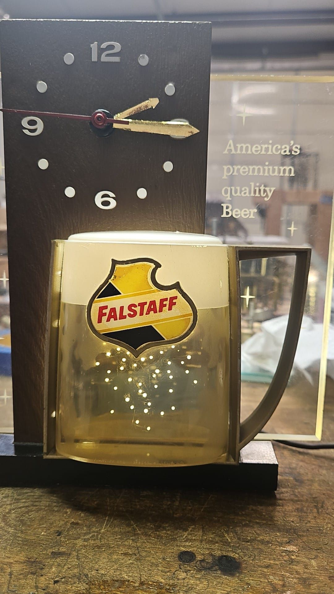 A clock with a beer mug on it is sitting on a table.