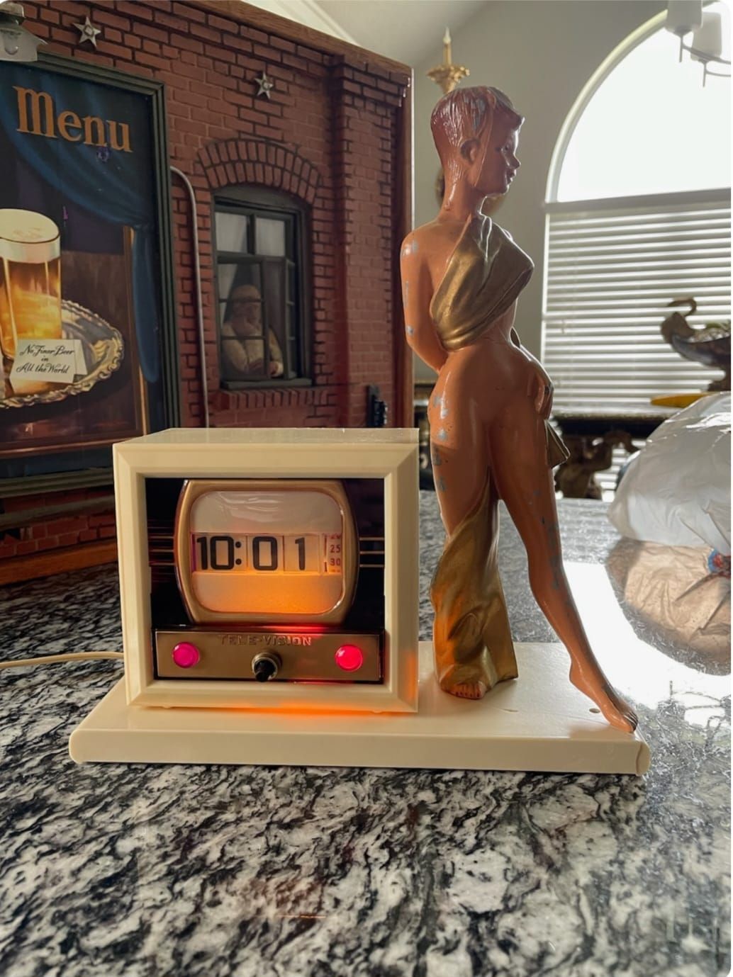 A statue of a woman standing next to a clock that says 10:01