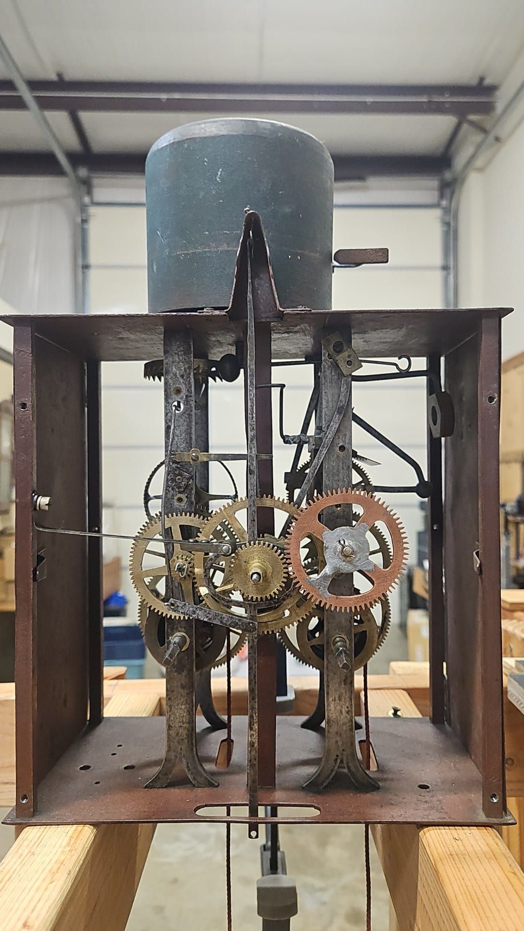A large clock is sitting on top of a wooden table.