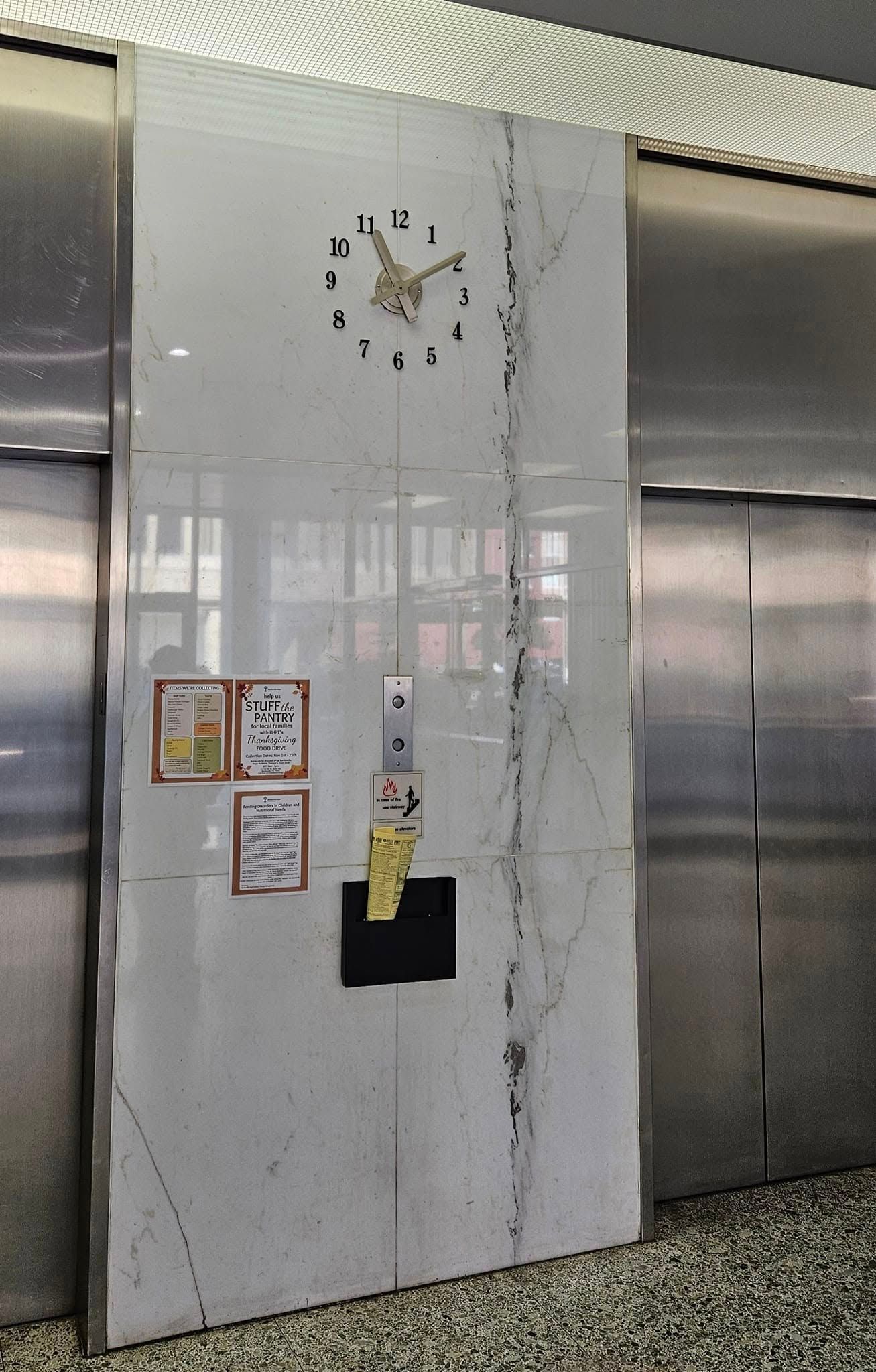 A clock on a wall in an elevator shows the time as 10:10