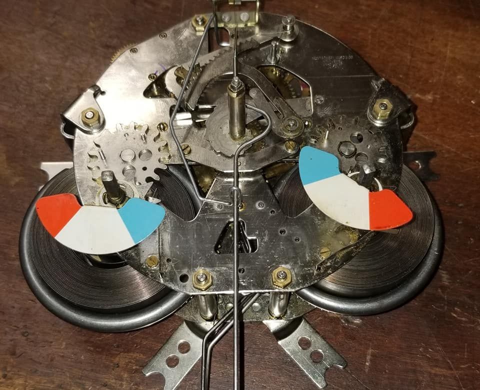 A close up of a clock with a red white and blue dial