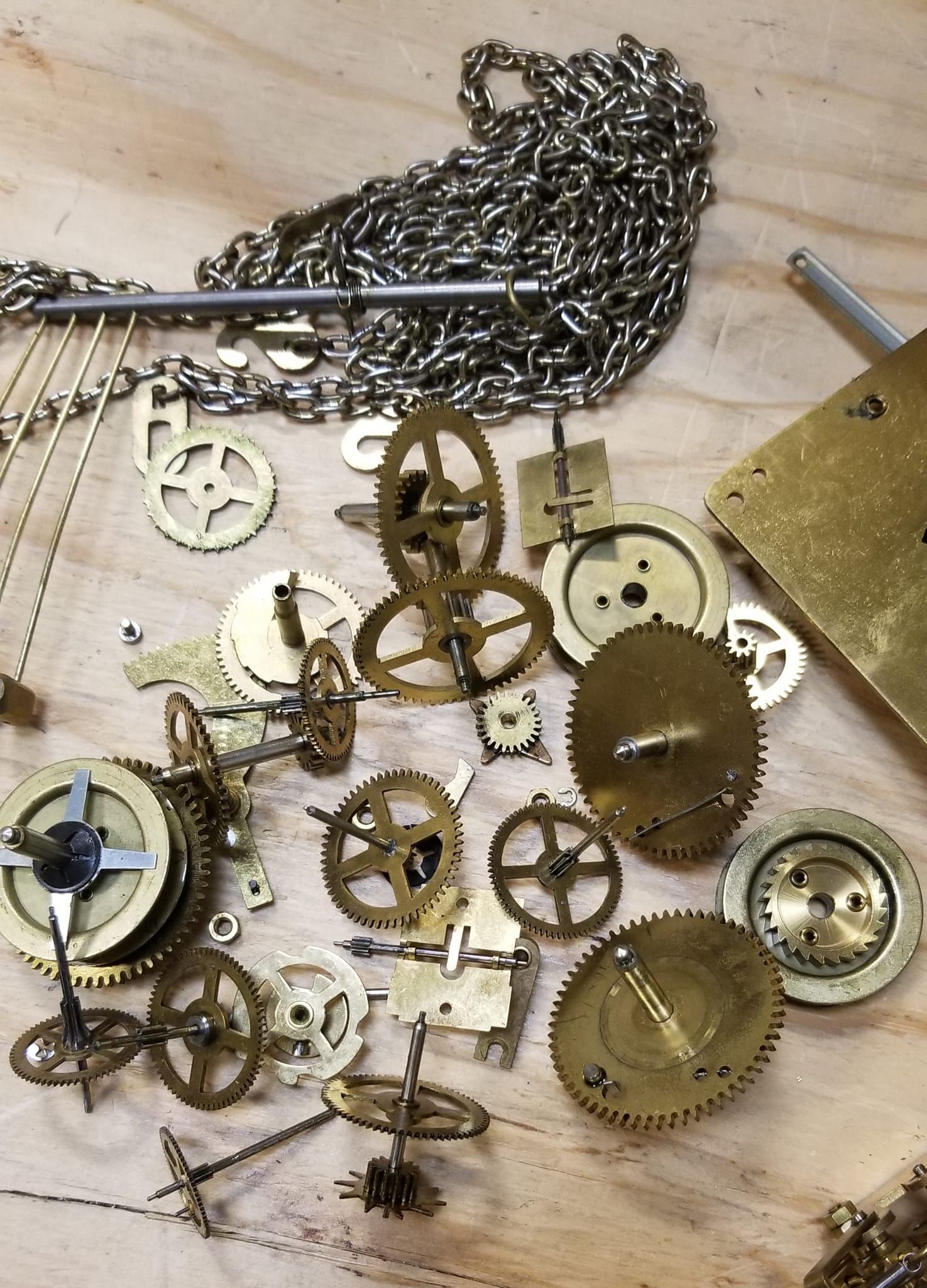 A pile of clock parts on a wooden table
