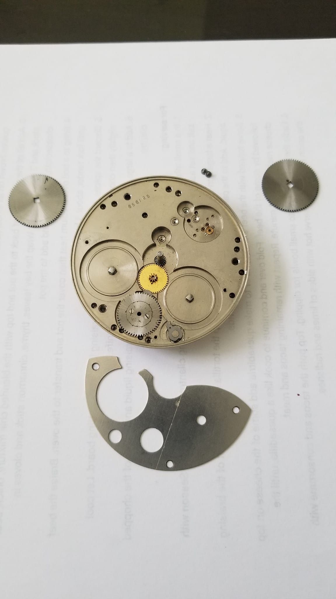 A close up of a watch mechanism on a piece of paper.