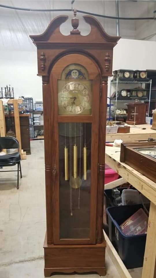 A large wooden grandfather clock is sitting in a room.