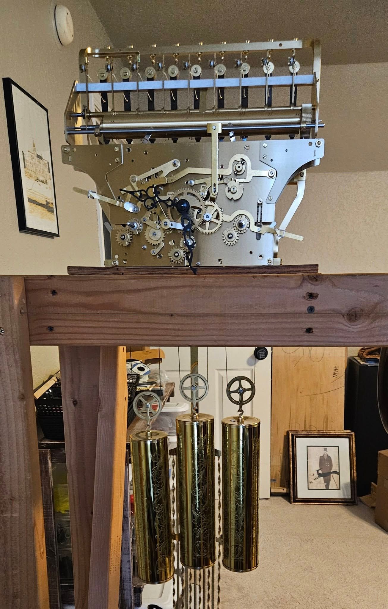 A large clock is sitting on top of a wooden shelf in a room.