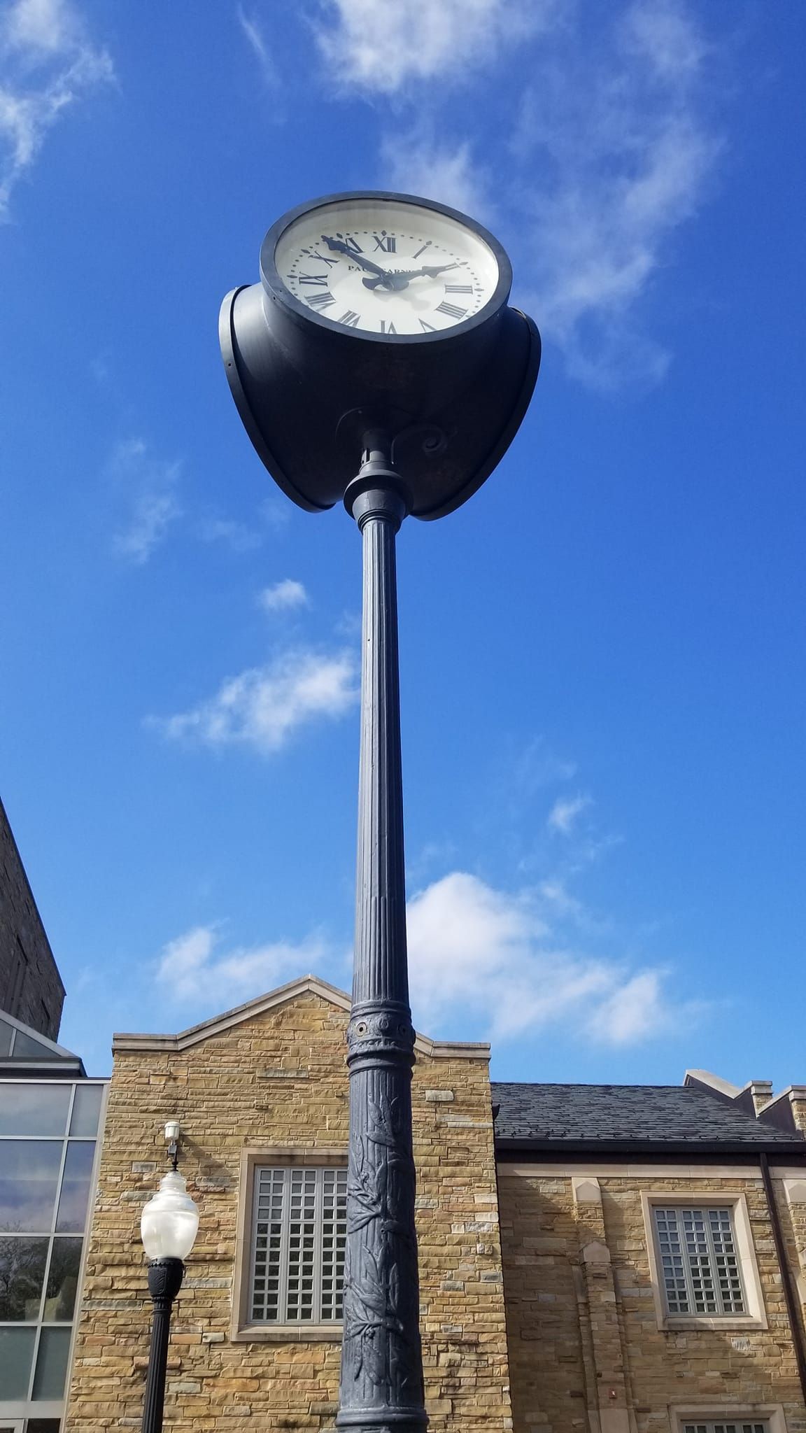 A clock on a pole with a blue sky in the background