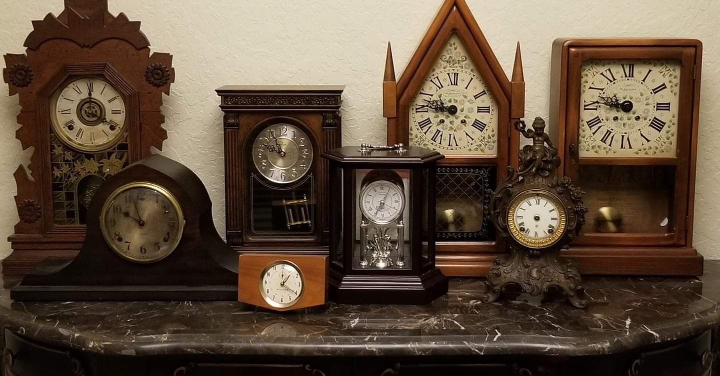 A group of clocks are lined up on a marble table.