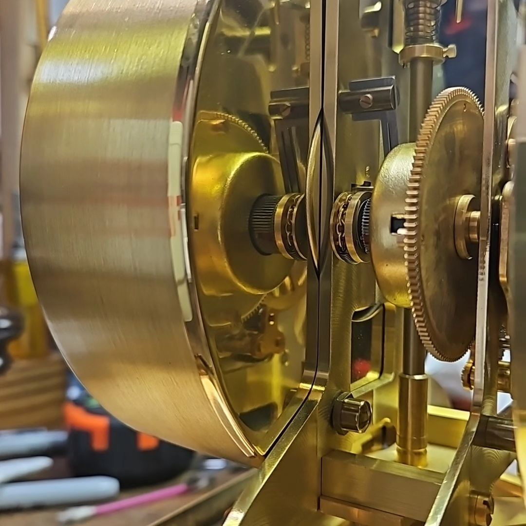 A close up of a clock with gears on it