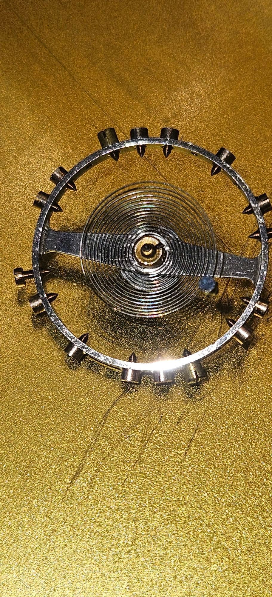 A close up of a steering wheel on a gold surface.