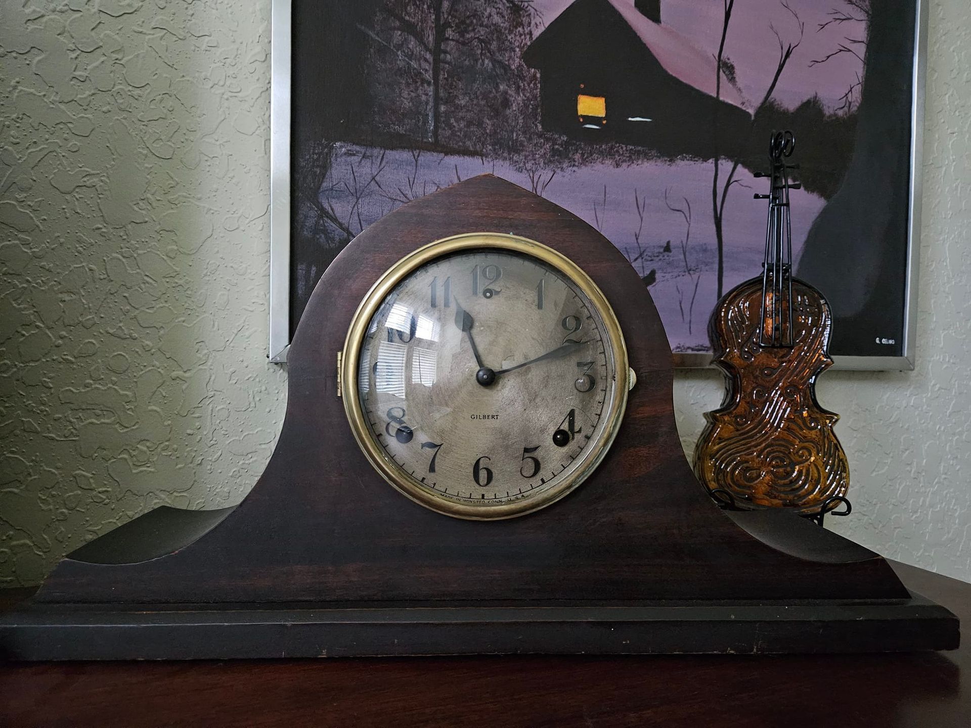 A wooden clock with a violin next to it