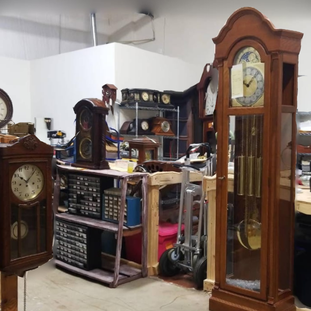 A room full of clocks including a large grandfather clock