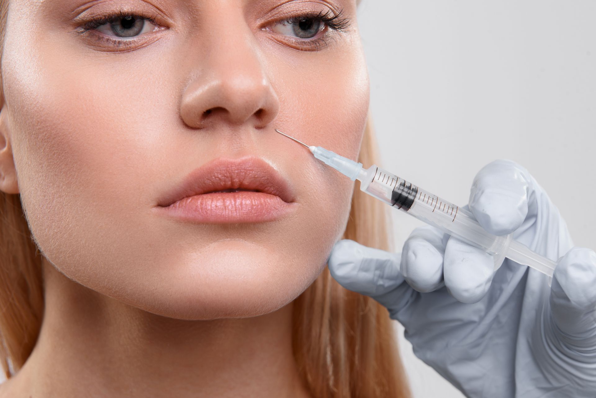 Eine Frau bekommt eine Botox-Injektion ins Auge.