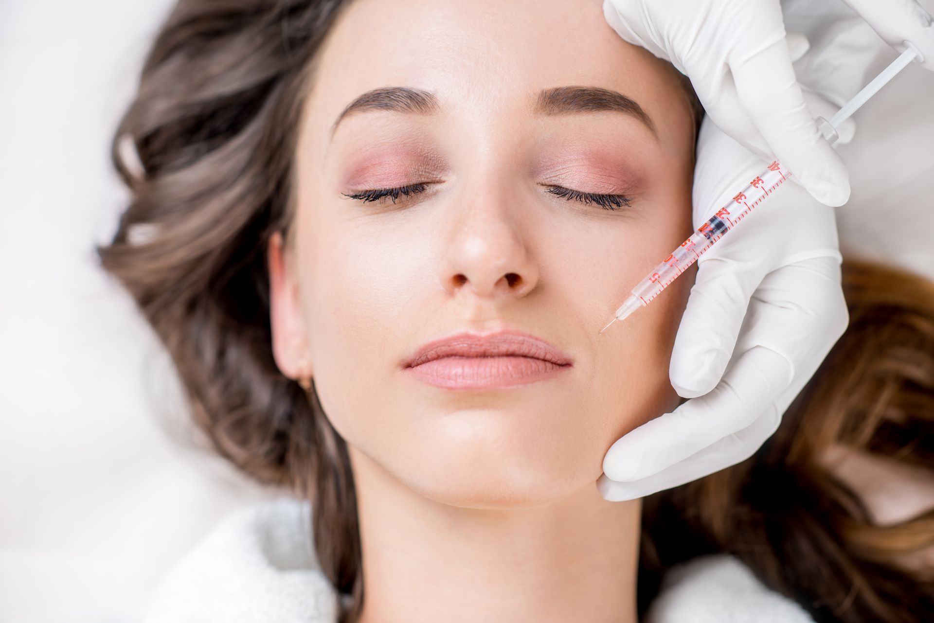Eine Frau bekommt eine Botox-Injektion ins Gesicht.