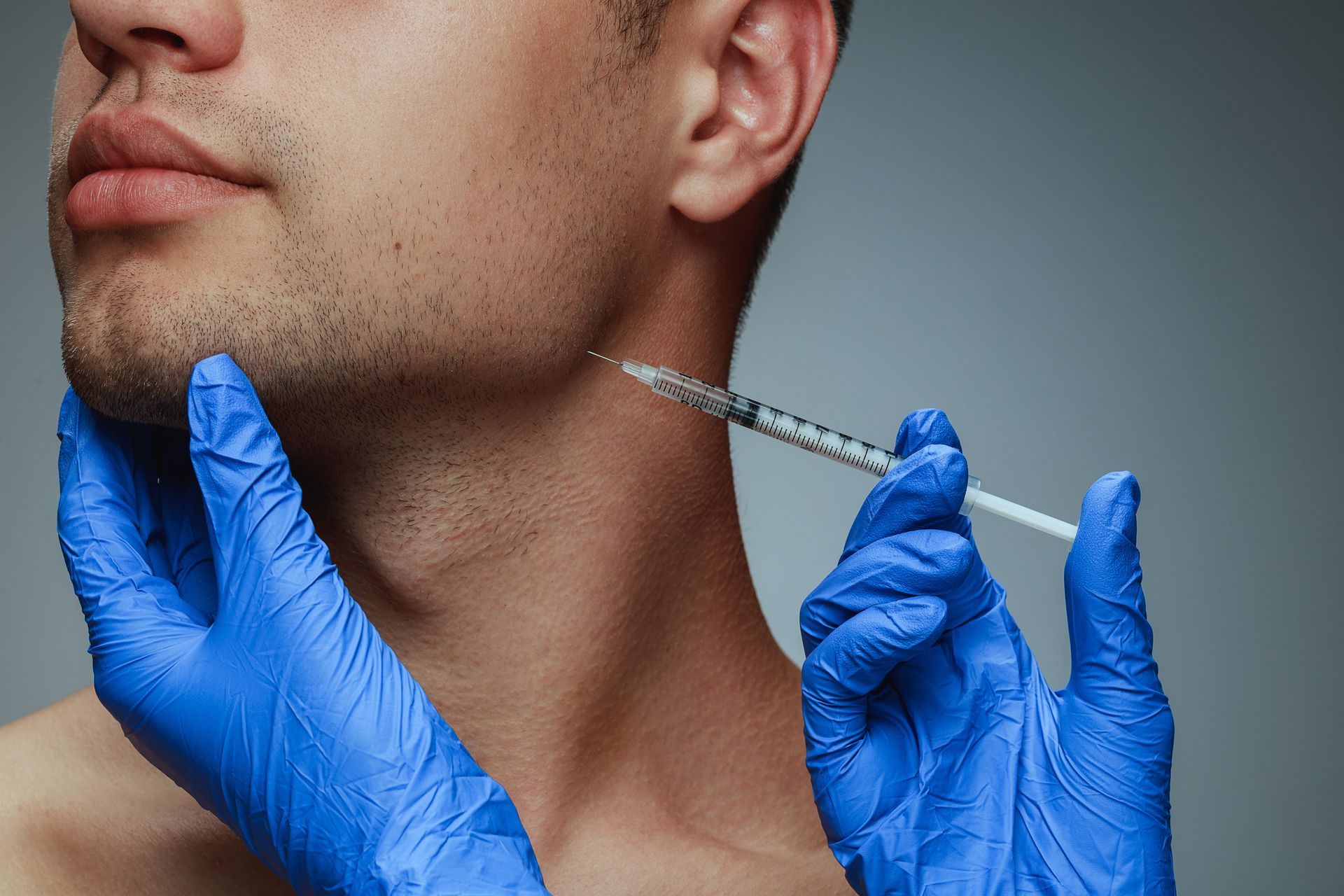Ein Mann bekommt eine Botox-Injektion in den Nacken.